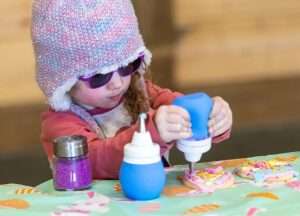 Children doing cookie decoration at the Kustermans Easter festival activity station