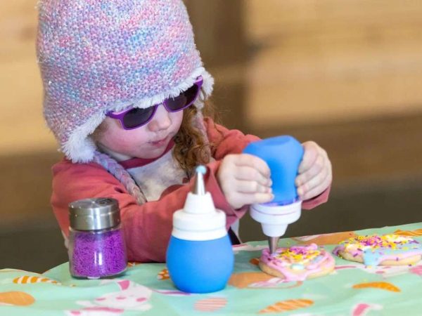 Children doing cookie decoration at the Kustermans Easter festival activity station