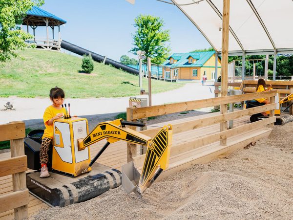 Child operating a mini excavator at the Diggerland attraction at Kustermans