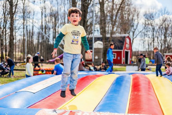 Child jumping high on the giant inflatable jump pillow at Kustermans farm