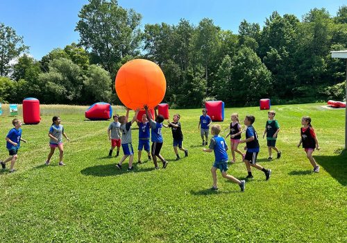 Kids playing kin-ball on the soccer field at Kustermans summer camp